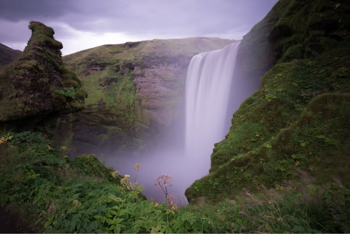A waterfall in a green canyon